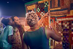 A Black family admires quilts at the Lewis Museum