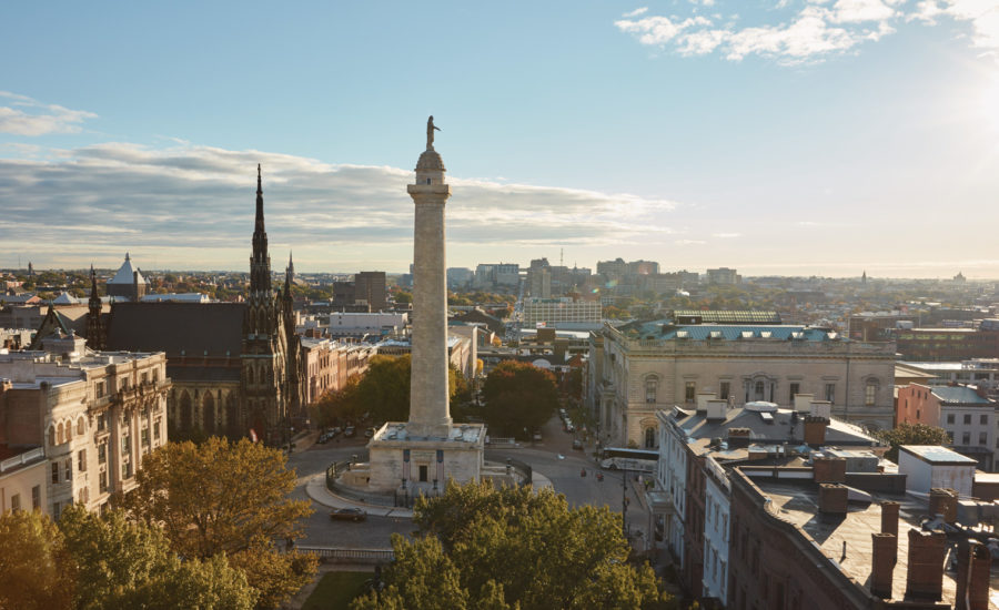 person skating at a skate park with the baltimore skyline in the background