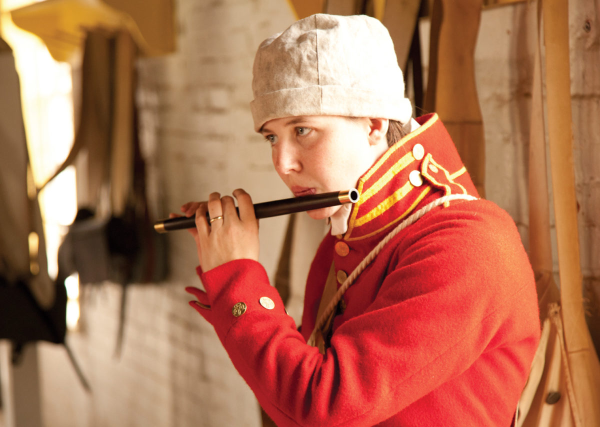 A farb plays the flute behind the ramparts of Forth McHenry.