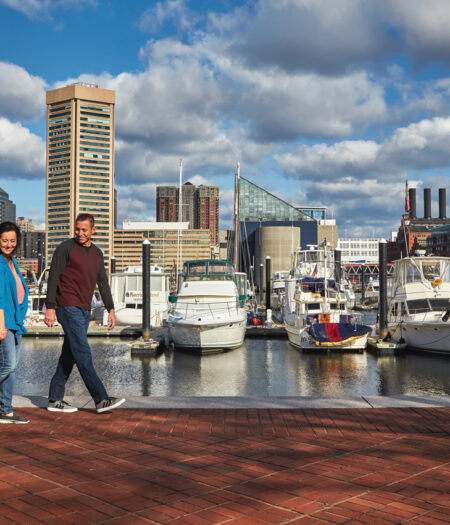 Family walking along the water in the Inner Harbor.