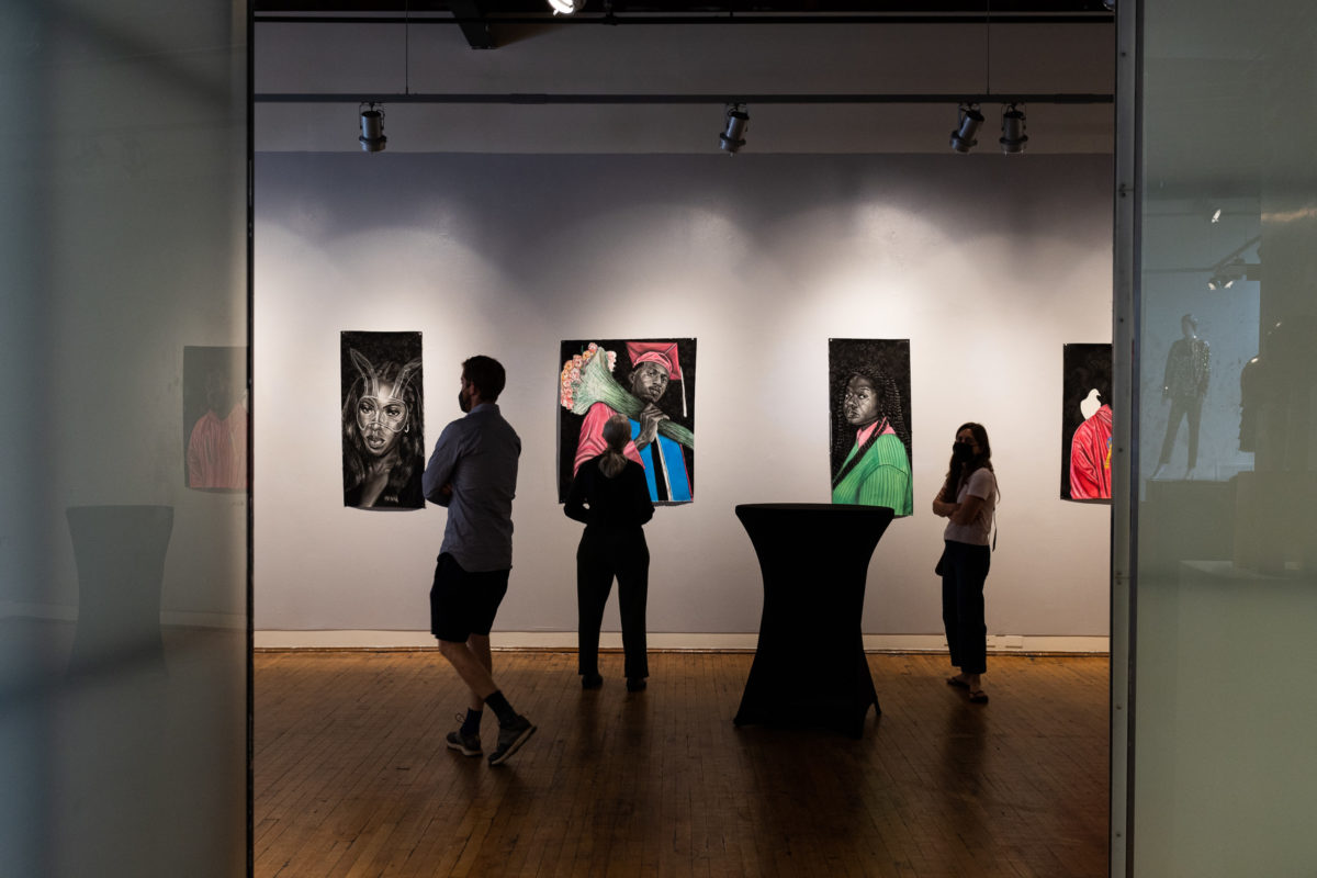 A crowd looks at sketches of African Americans in the gallery space at the Eubie Blake Cultural Center.
