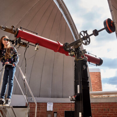 Child looking through a telescope at The Baltimore Science Center.