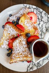 french toast covered in powdered sugar and fruit