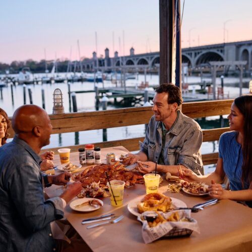people eating crabs outside at picnic tables