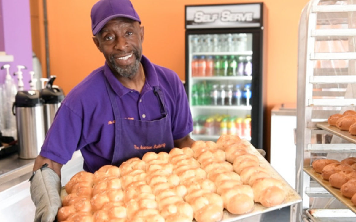 Baker holding up baked goods at the Avenue Bakery