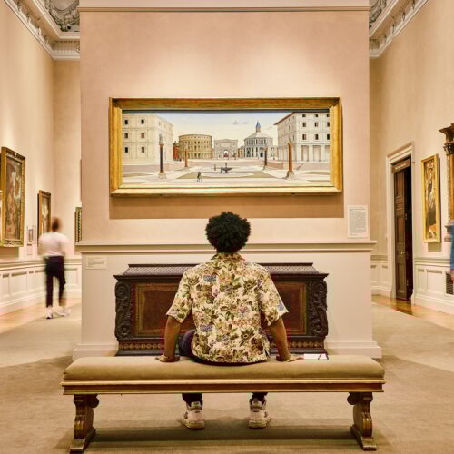 person sitting and looking at art on the wall