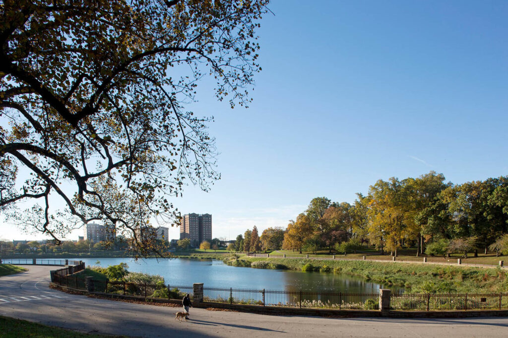 Man walks his dog next to the reservoir in Druid Hill Park