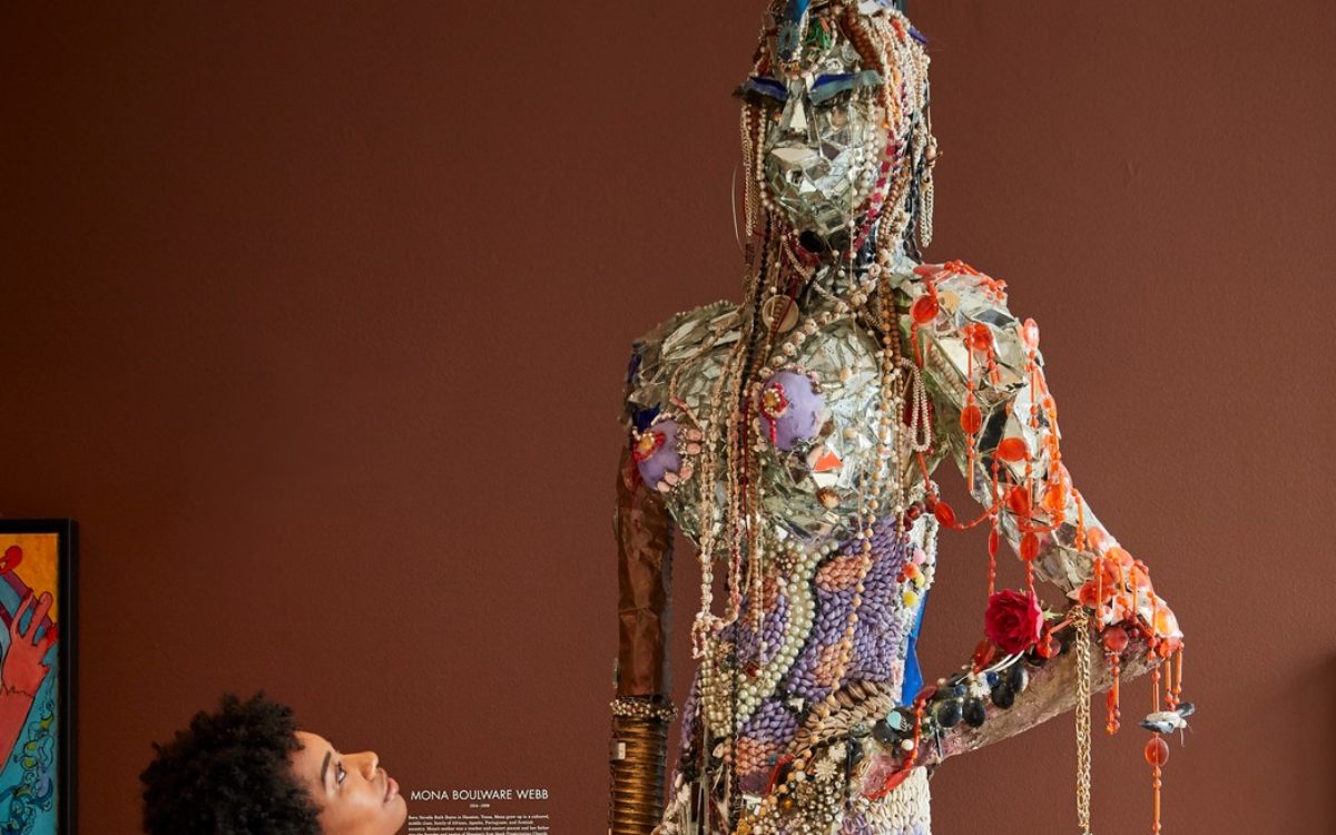 A woman admires a bejeweled statue at the American Visionary Art Museum