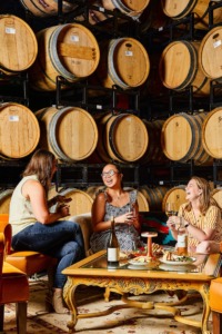 Women laughing with wine barrels